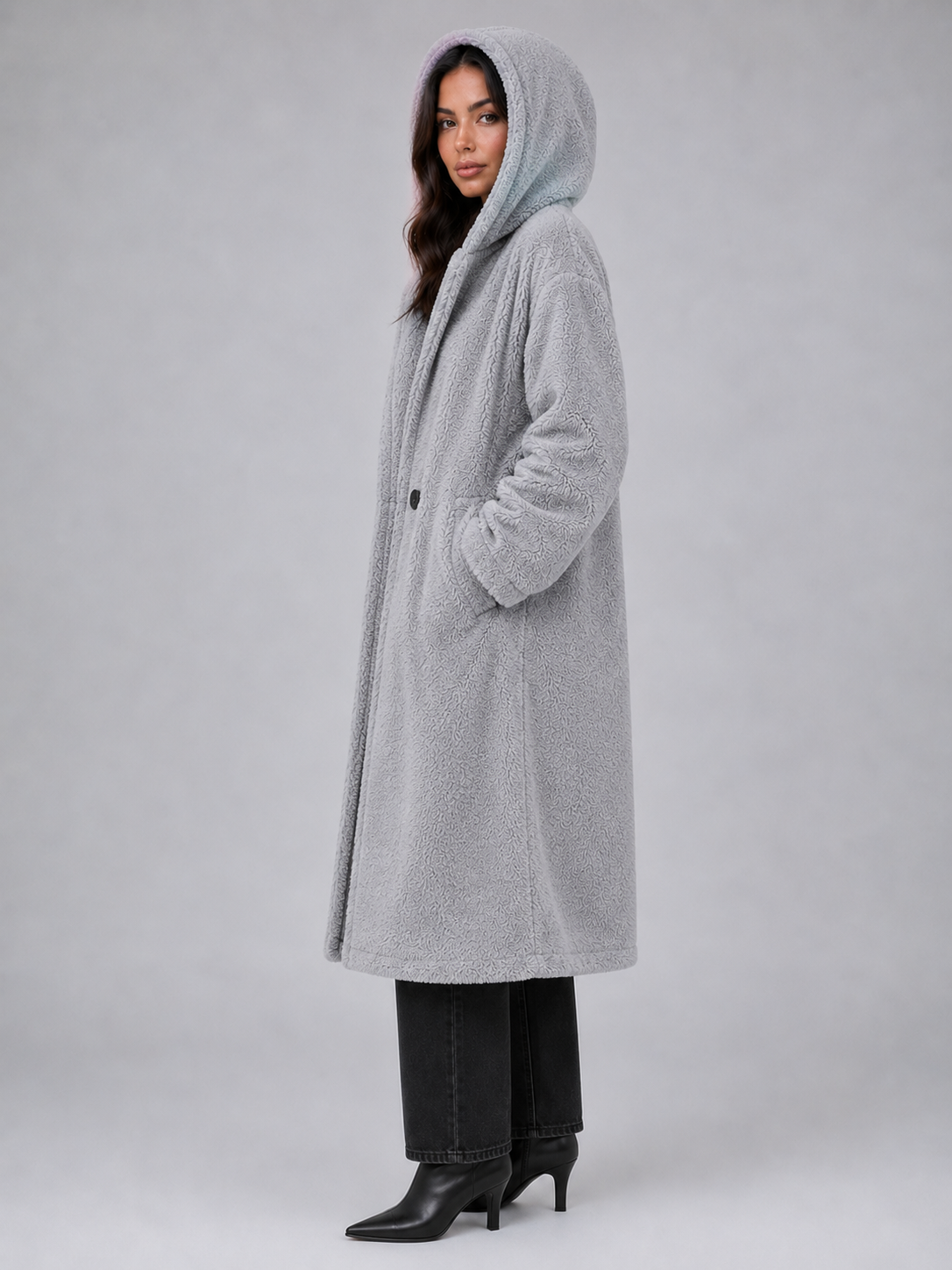 Woman wearing light gray oversized hooded teddy coat with black denim jeans and black kitten heel boots