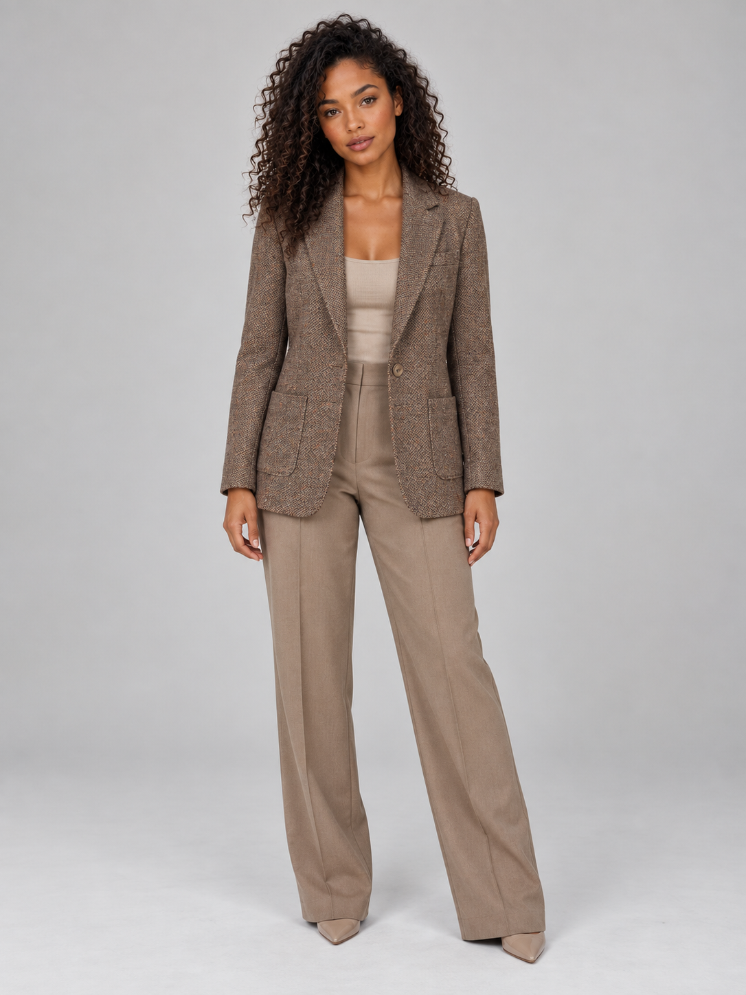 Woman wearing beige single-breasted wool blend blazer with matching trousers and cream camisole, styled for smart casual wear
