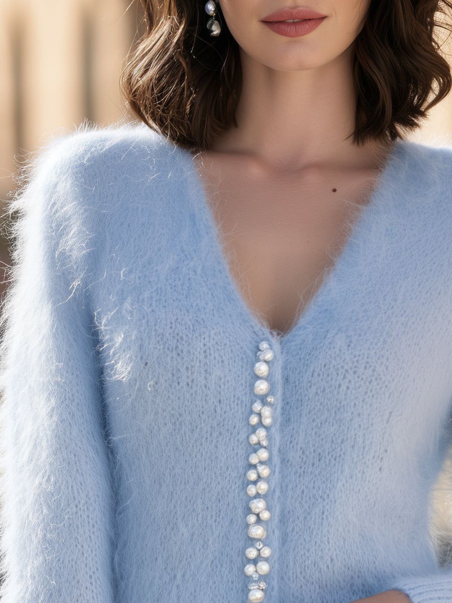 Woman wearing light blue fuzzy knit V-neck cardigan with pearl button embellishments down the front