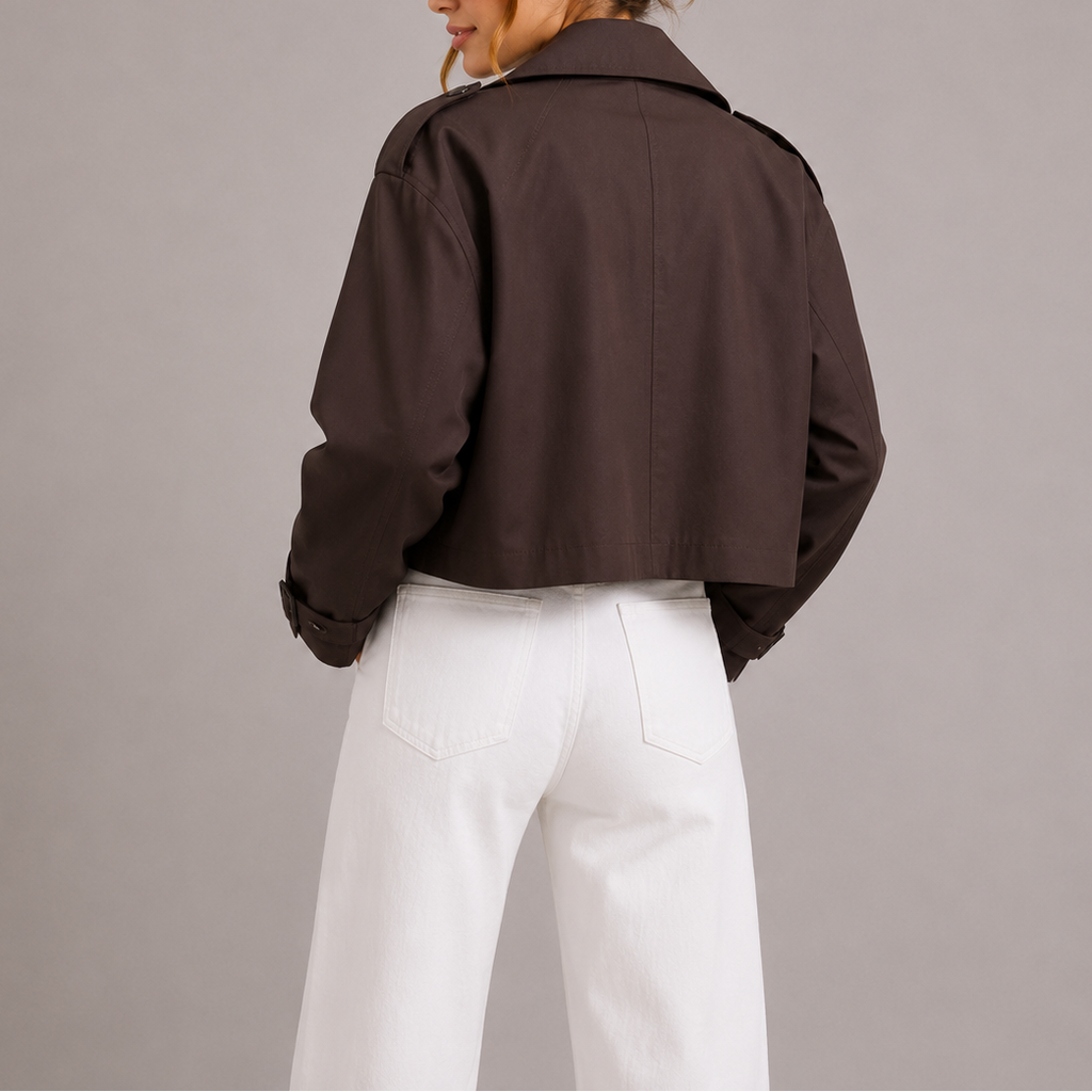 Woman wearing brown cropped trench jacket with white jeans, back view
