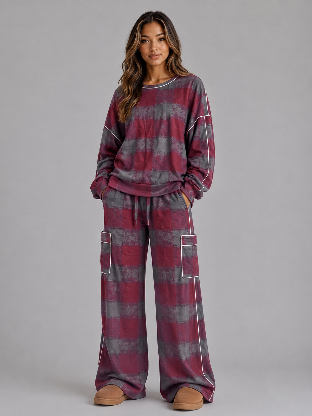 Woman wearing burgundy and gray striped oversized sweatshirt with matching wide leg cargo lounge trousers and tan slippers