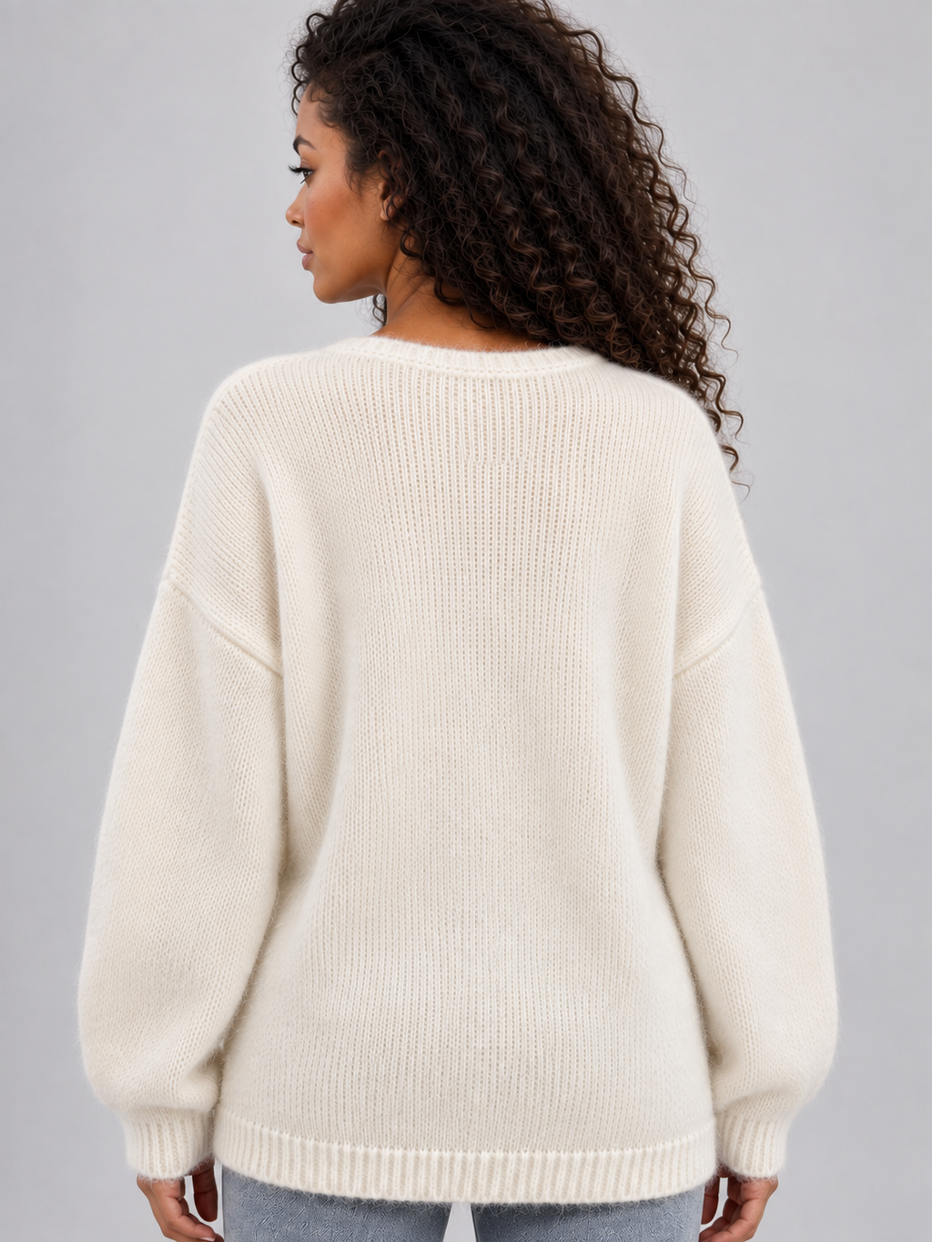 Woman wearing cream ribbed crew neck knit sweater with long sleeves, shown from back view