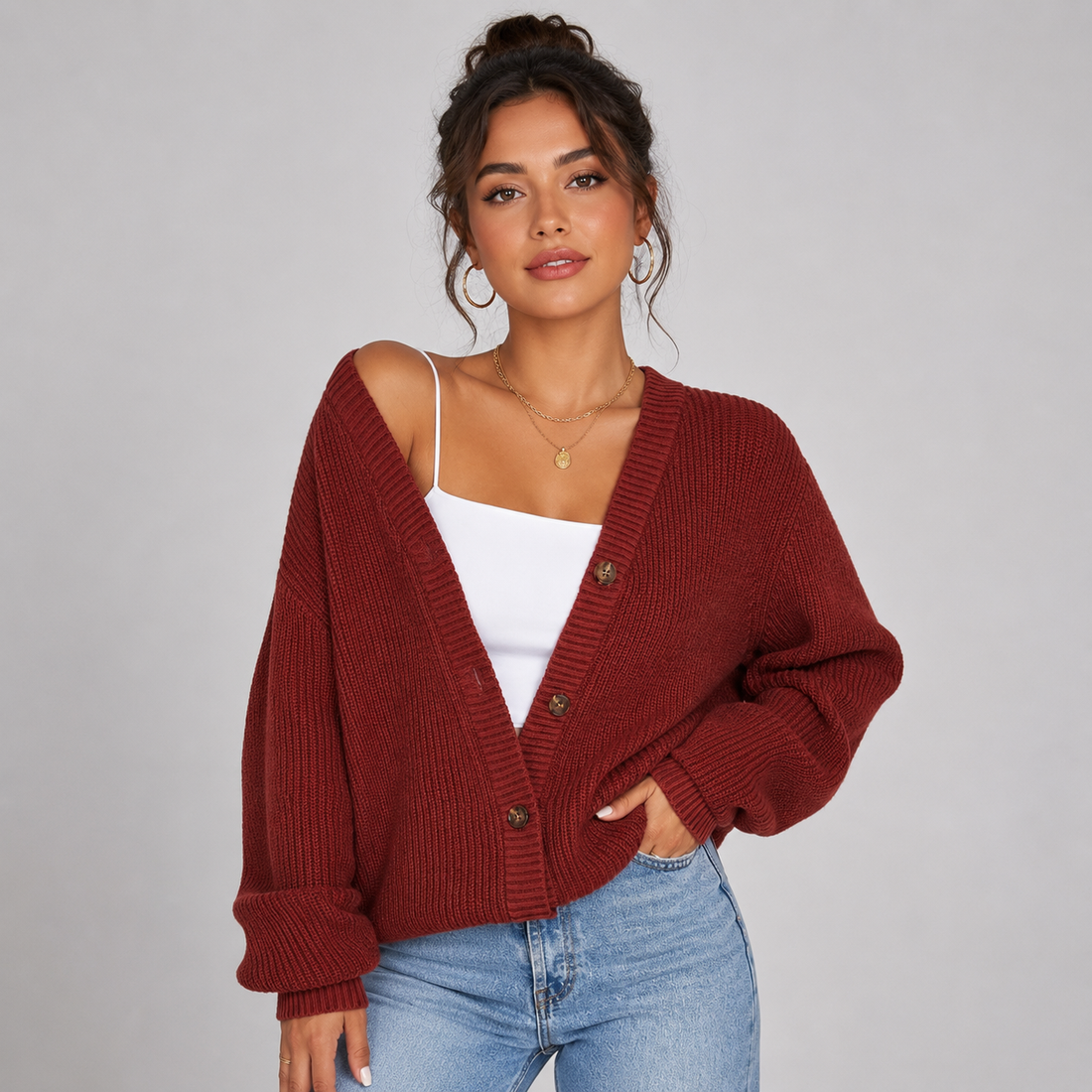 Woman wearing burgundy ribbed button-front cardigan over white camisole with light wash jeans