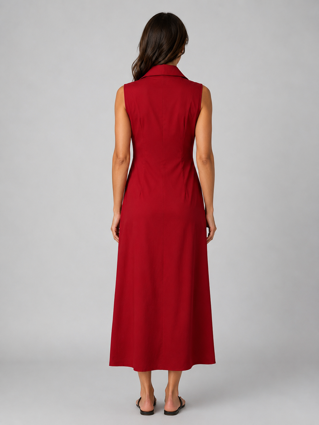 Woman wearing red sleeveless button-front maxi shirt dress with collar, shown from back view against gray background