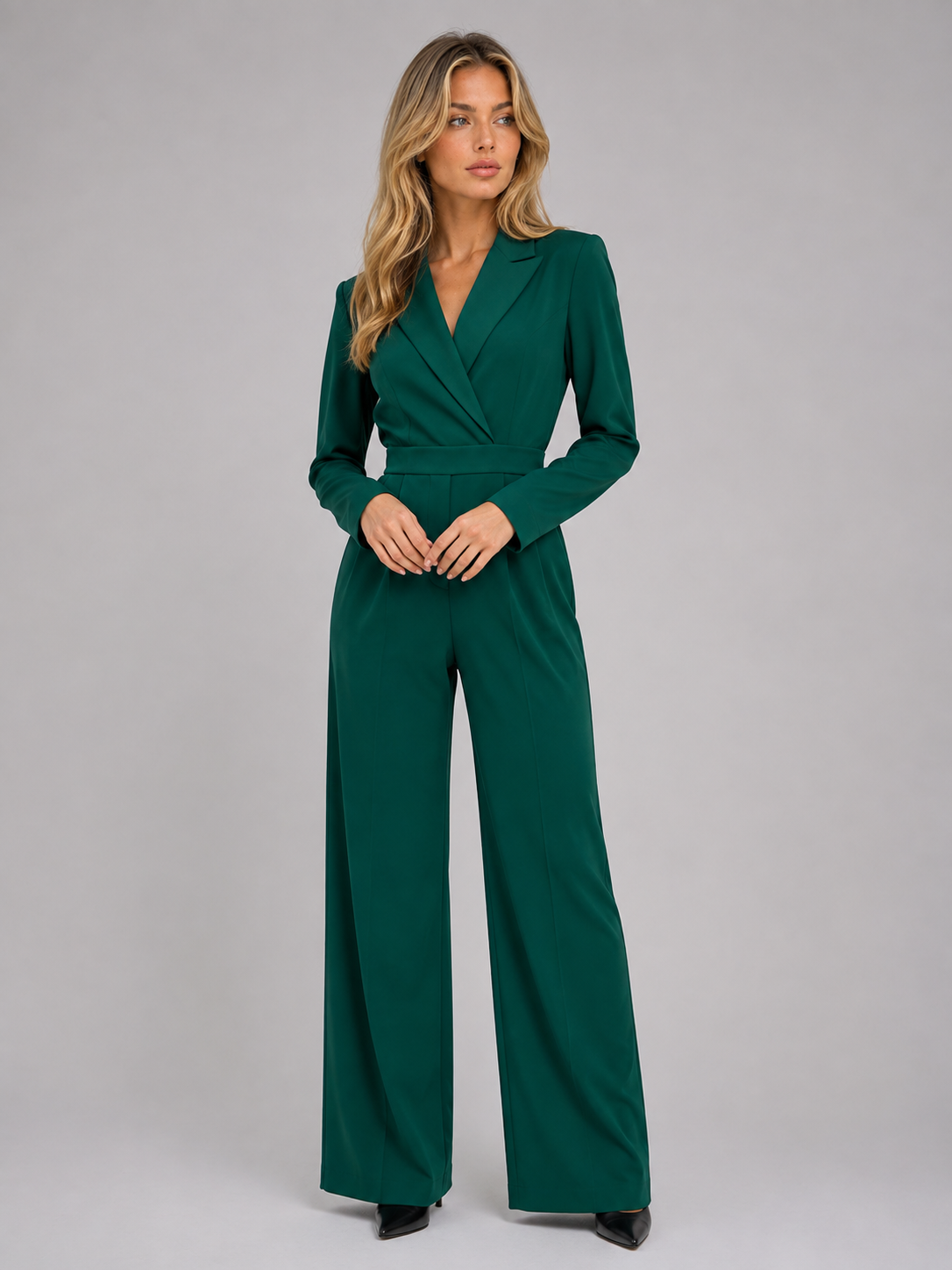 Woman wearing dark green belted wrap front wide leg jumpsuit with long sleeves and tailored collar