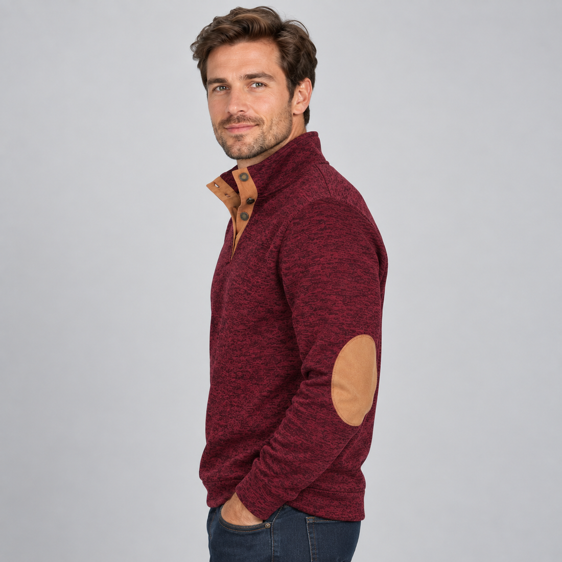 Man wearing burgundy heathered quarter button pullover with tan elbow patches and contrasting collar, styled with dark jeans