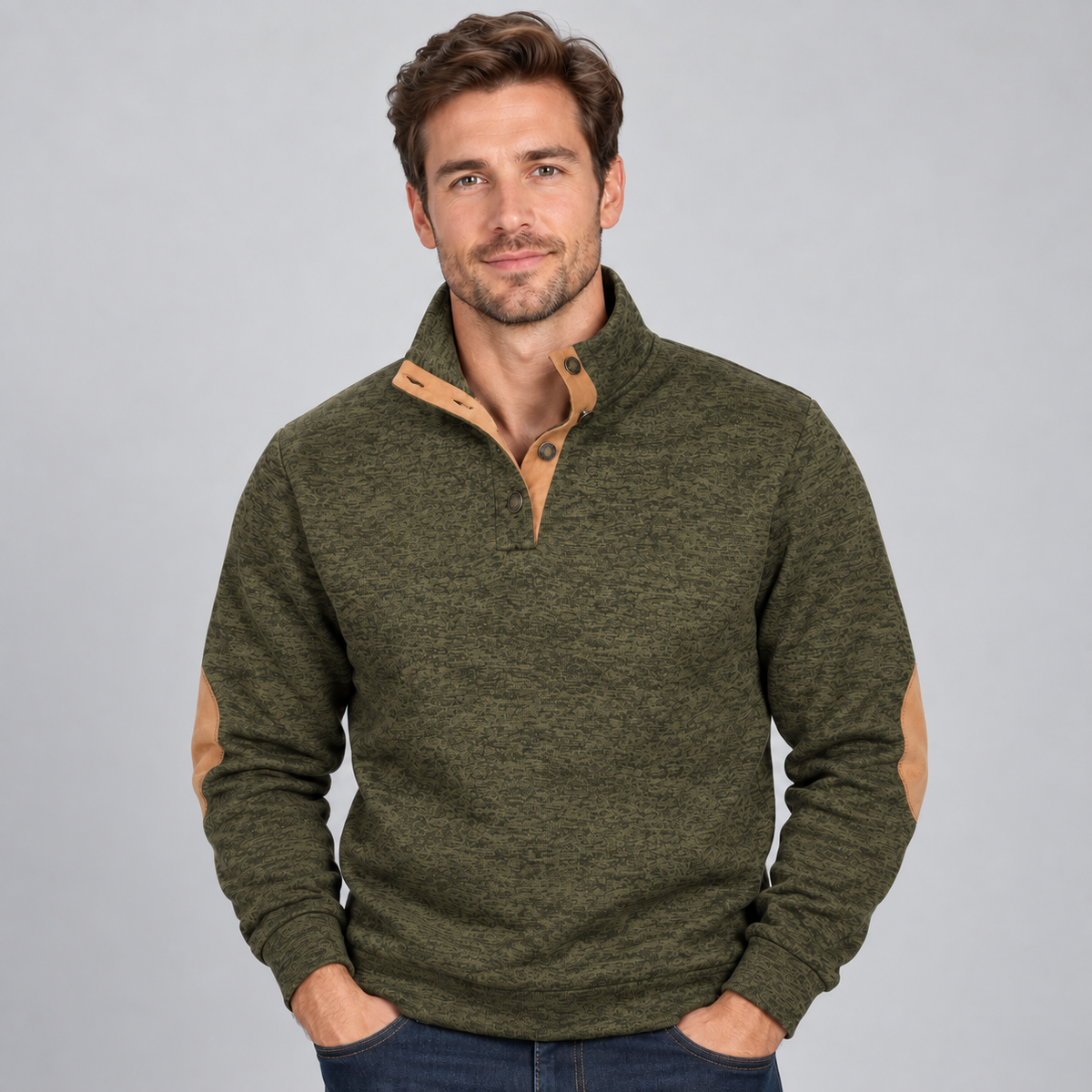 Man wearing olive green quarter button stand collar jumper with tan contrast trim and elbow patches, hands in pockets