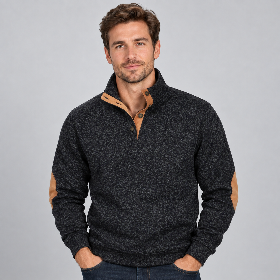 Man wearing charcoal grey quarter button stand collar jumper with tan suede elbow patches and navy jeans