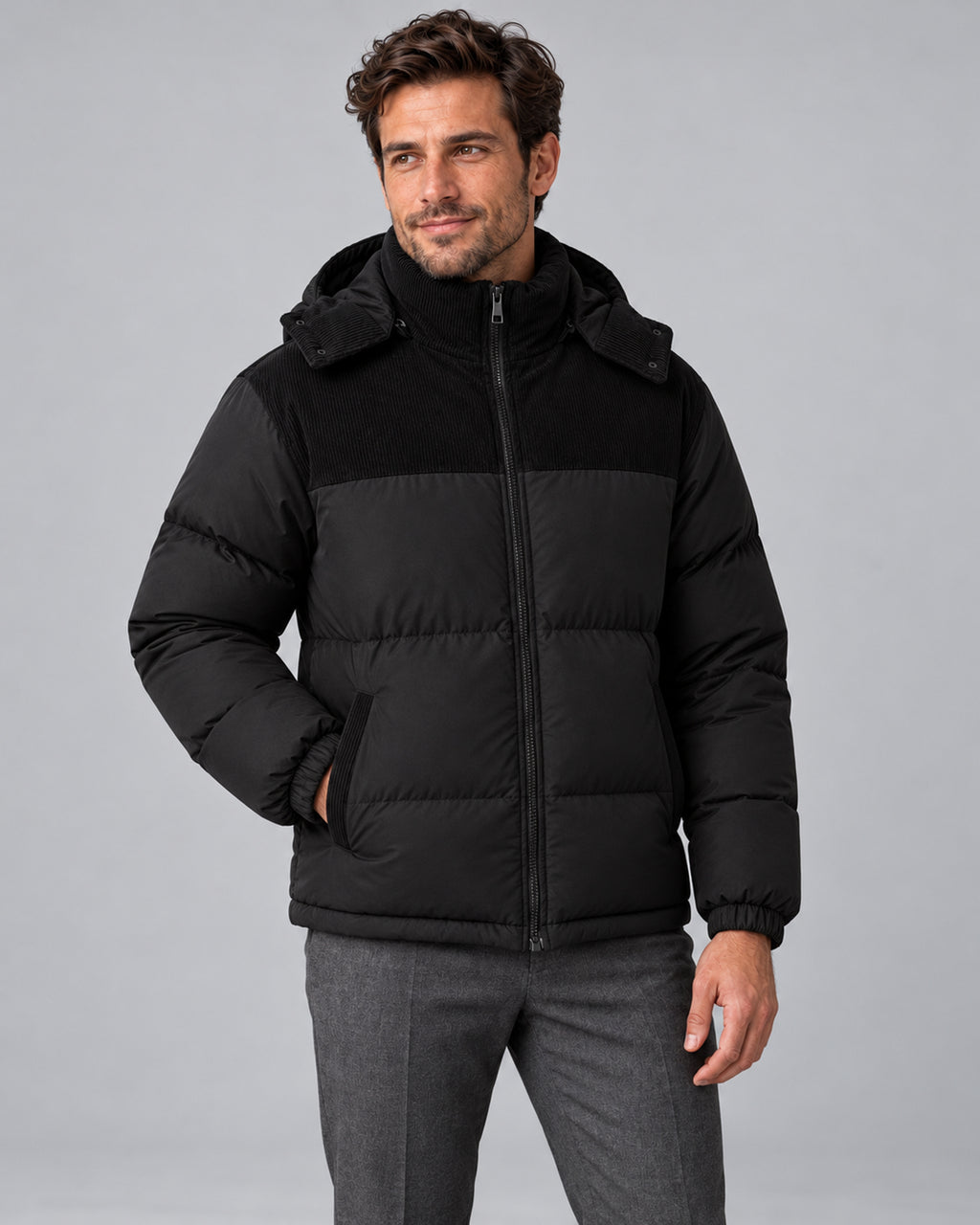 Men's hooded corduroy puffer jacket in black front, studio view