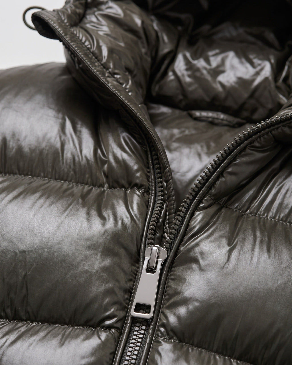 Original product close-up of glossy quilting, hood drawcord and silver zipper