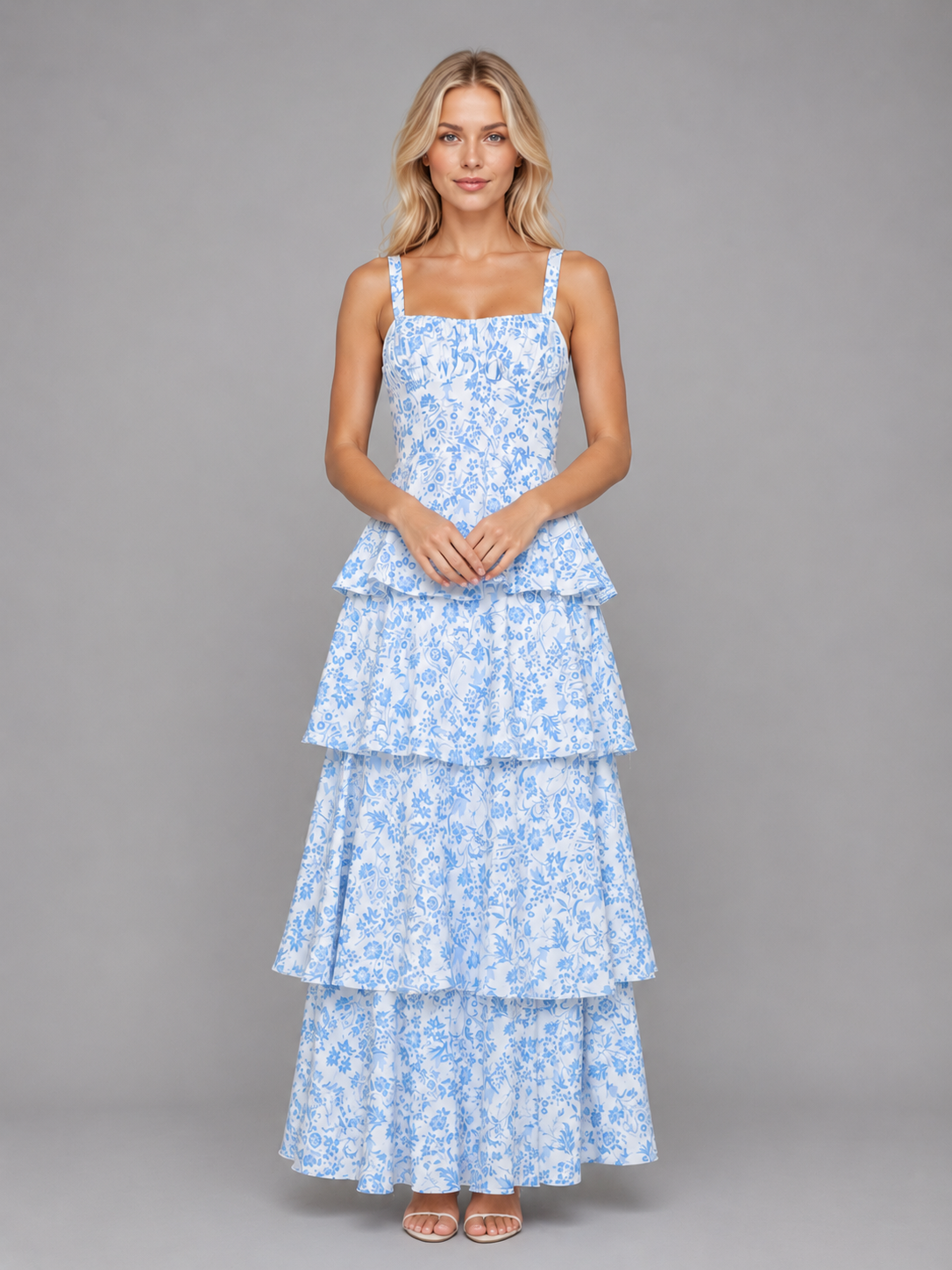 Woman wearing blue and white floral tiered maxi dress with square neckline and straps