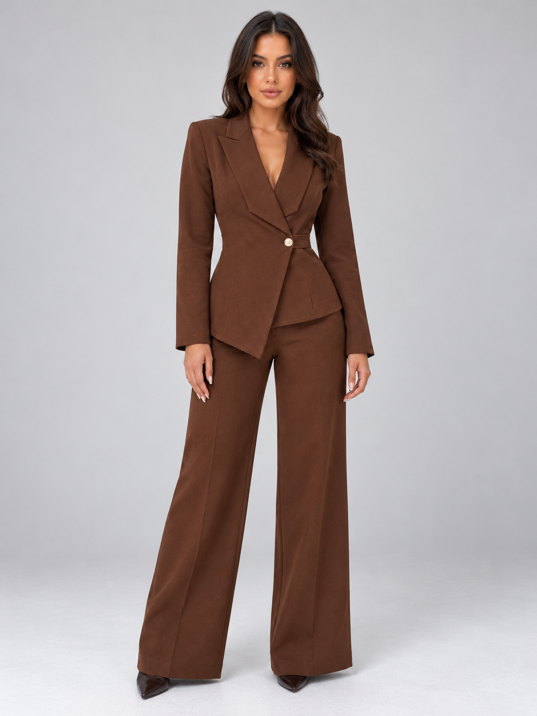 Woman wearing brown belted blazer with wrap front and matching wide leg trousers, styled as a tailored two-piece suit