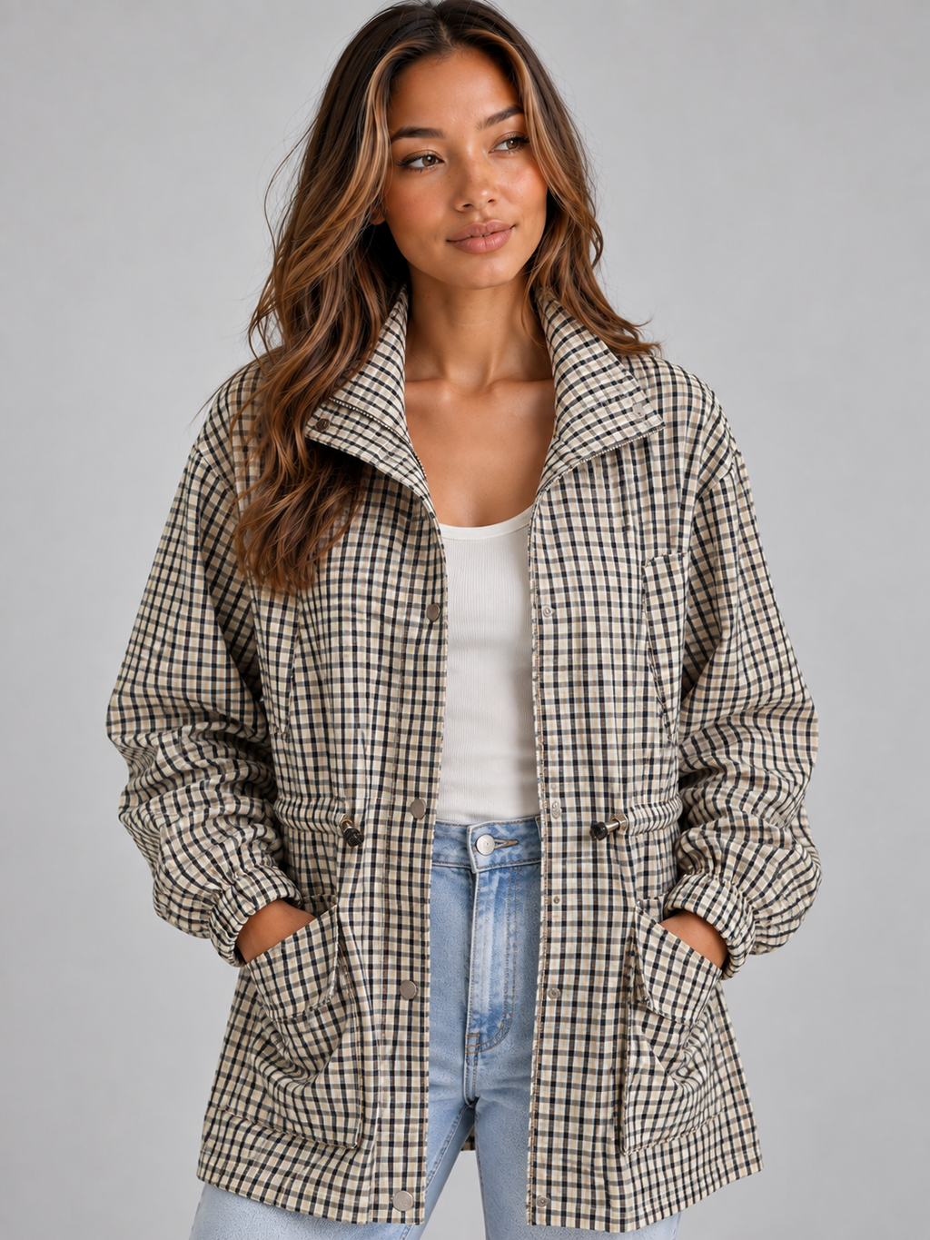 Woman wearing black and cream checked field coat over white top and blue jeans, with collared neckline and front pockets