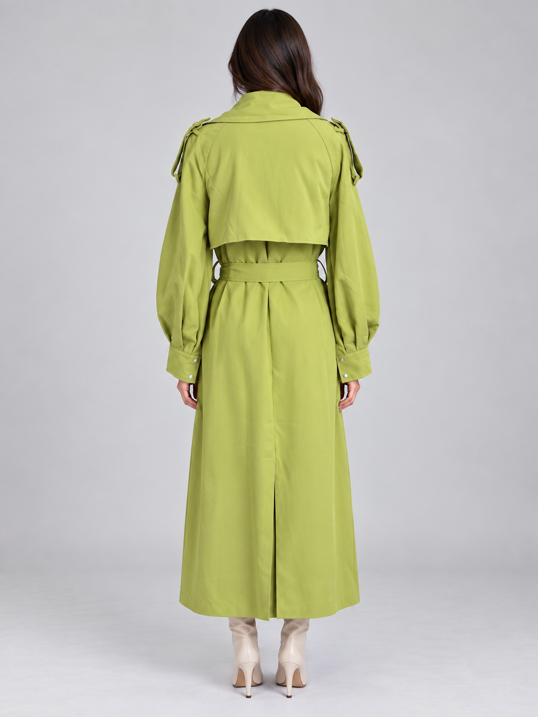Woman wearing lime green belted longline trench coat with puffed sleeves and double breasted buttons, shown from back view