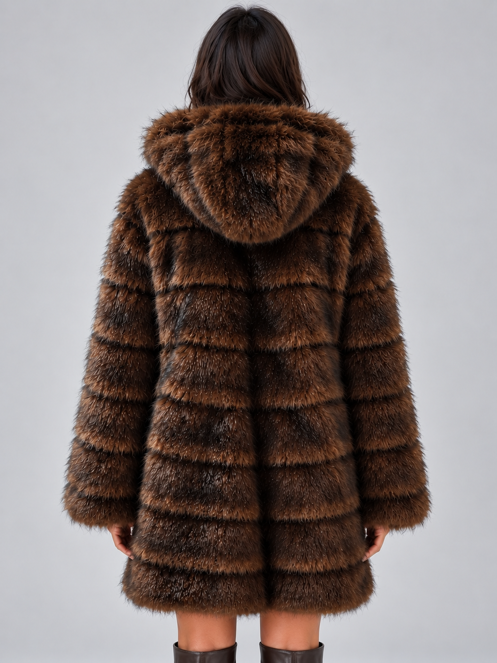 Woman wearing brown plush panelled faux fur hooded coat with horizontal stripe pattern, viewed from back