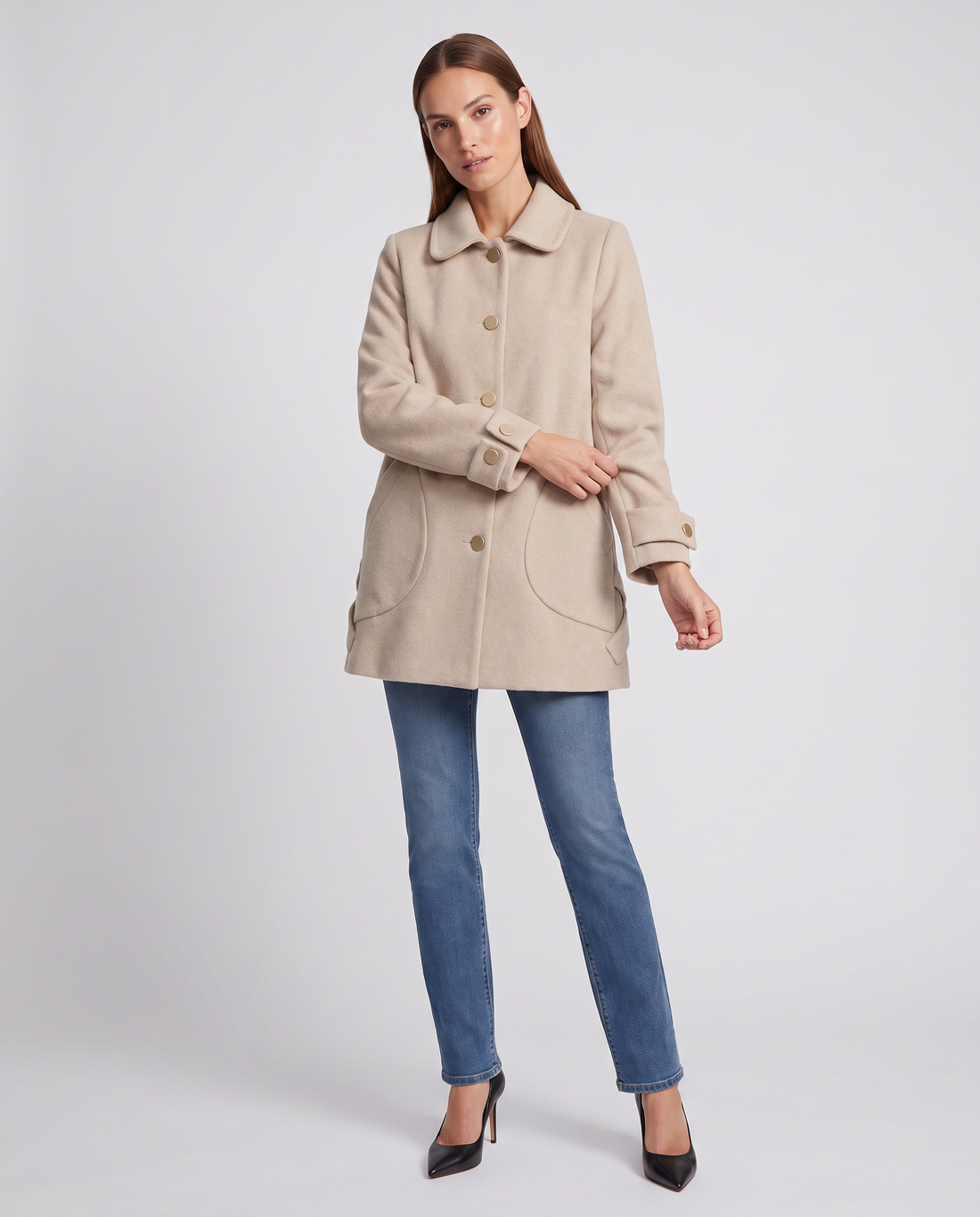 Woman wearing beige round collar oversized coat over blue jeans and black heels, styled as mid-length casual outerwear