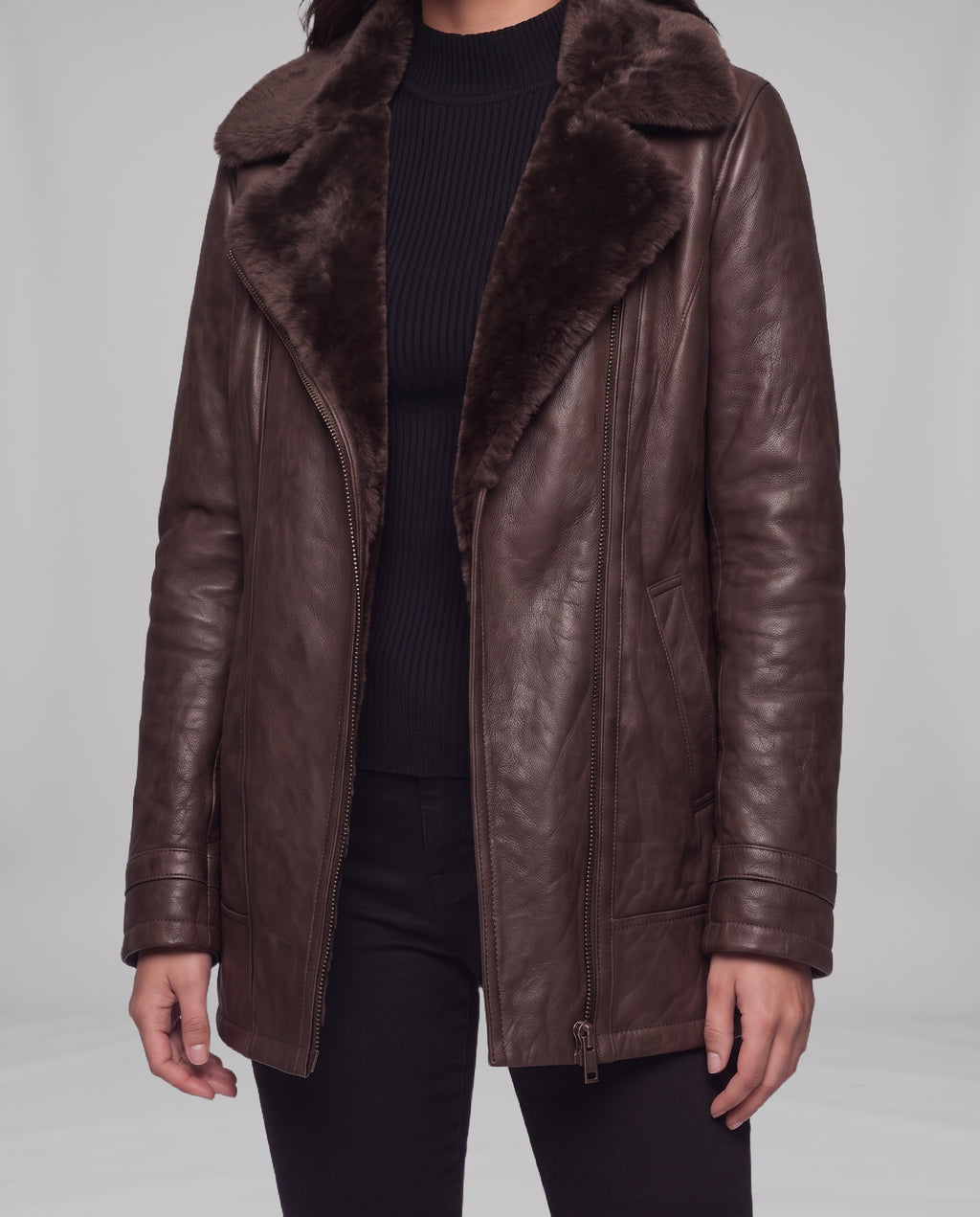 Close-up of the Elegance brown leather jacket showing shearling lapel, front zip, panel seams and side pocket