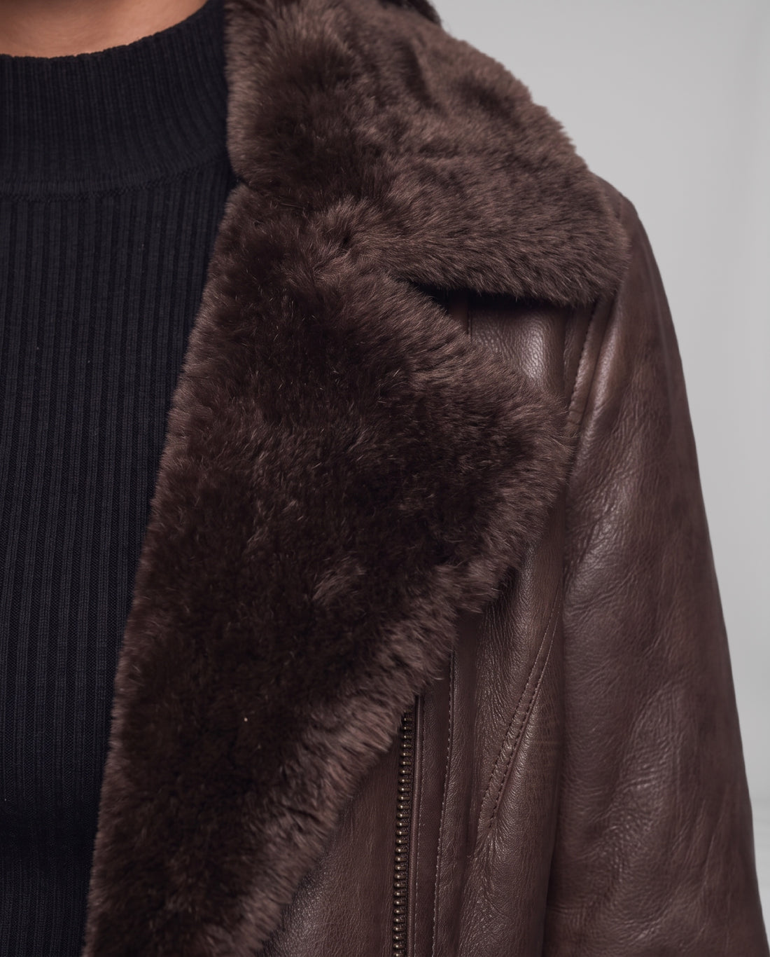 Detail of the plush dark-brown shearling collar and leather edge on the Elegance jacket