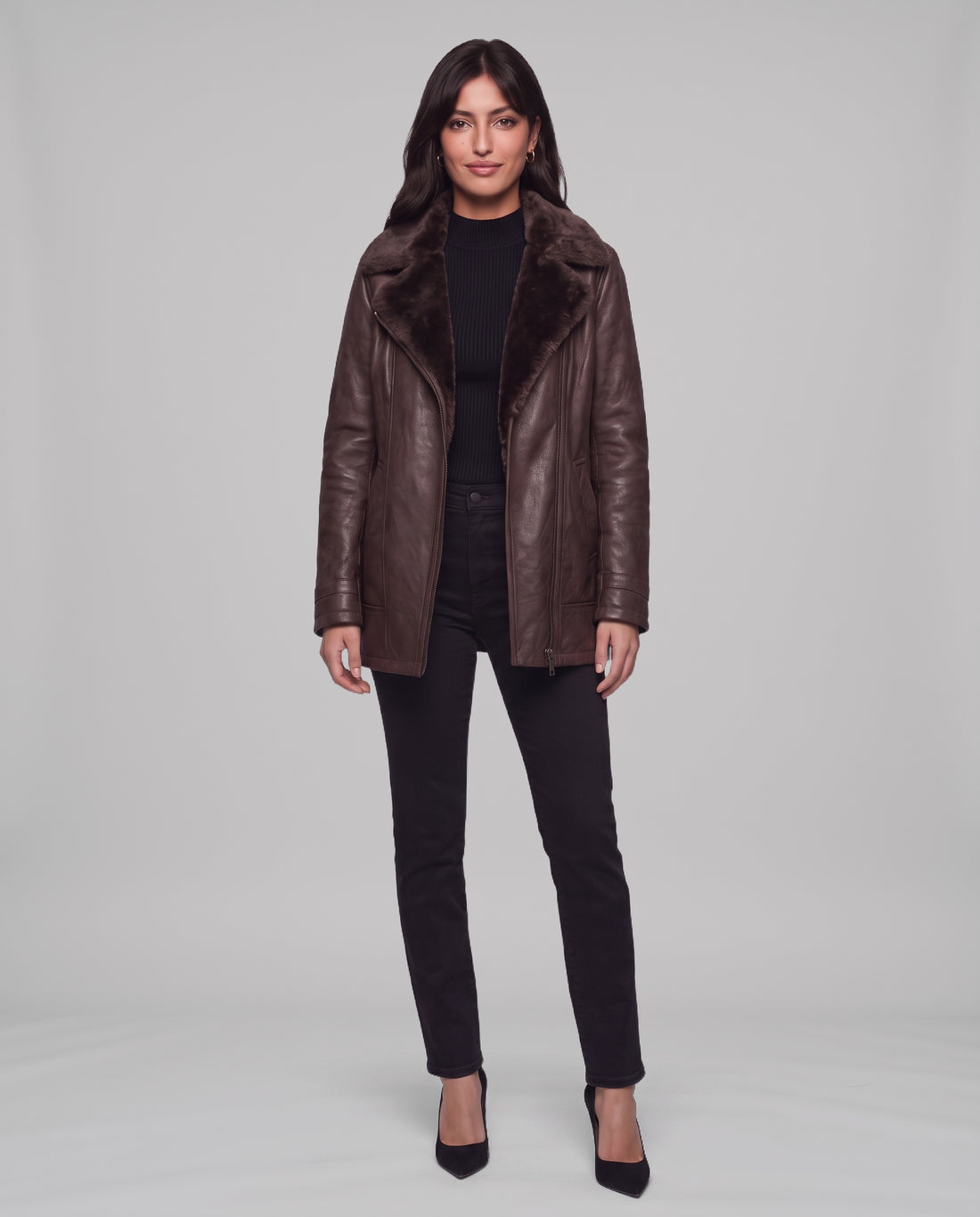 Full-length view of a model wearing the Elegance brown shearling-lined leather jacket with black jeans and heels