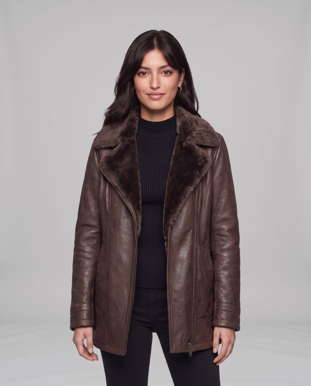 Model wearing the Elegance women's shearling-lined leather jacket in brown, open over a black ribbed high-neck top, front view
