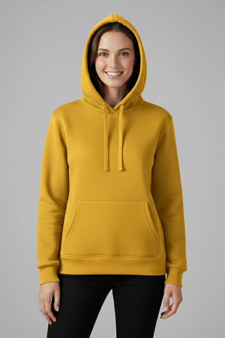 Woman wearing mustard yellow hoodie with adjustable drawstrings and front pocket, paired with black pants